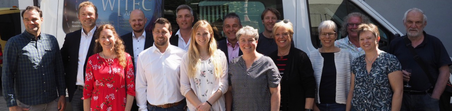 Gruppenfoto mit Sponsoren vor Kleinbus stehend