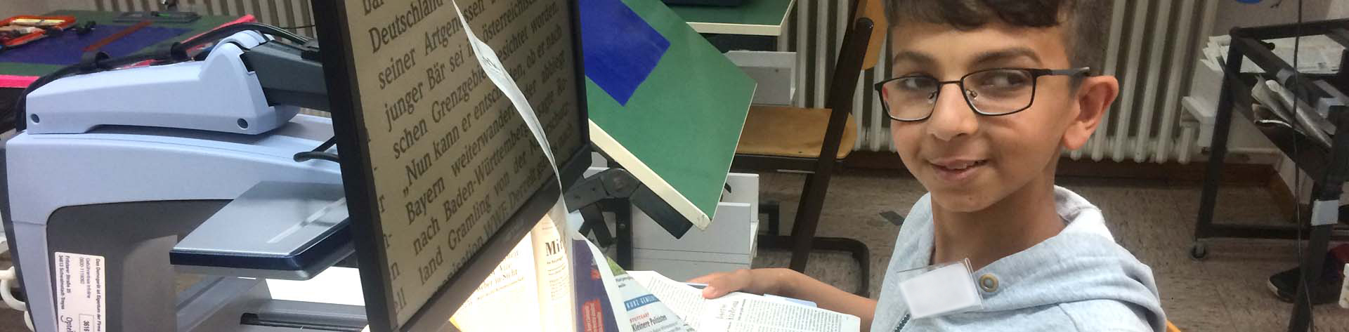 Schüler liest am Lesegerät Zeitung