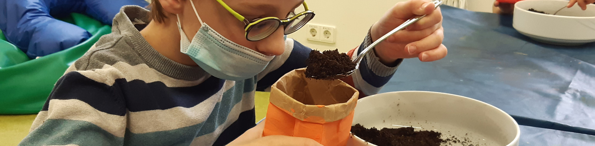 Schüler macht Experiment mit Filter und Erde